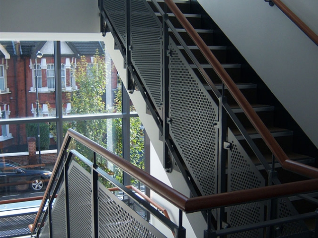 Stairs with perforated sheet infill panels and timber handrail